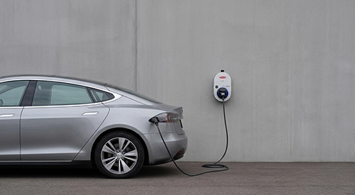 EV charger mounted on an exterior wall of a Joondanna house with cable connected to a car